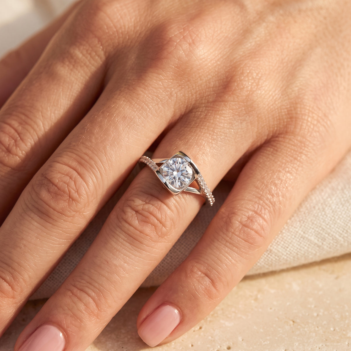 Top view of the round-cut simulated diamond solitaire ring in sterling silver worn on a woman's finger.