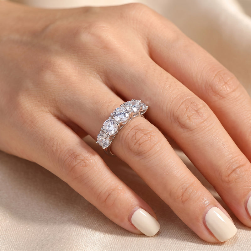 Top-down view of the Claralise sterling silver five-stone round-cut simulated diamond ring worn on a finger.