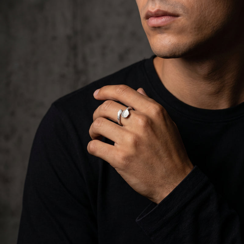 Model wearing the silver bark-textured open ring on his middle finger against a black shirt.