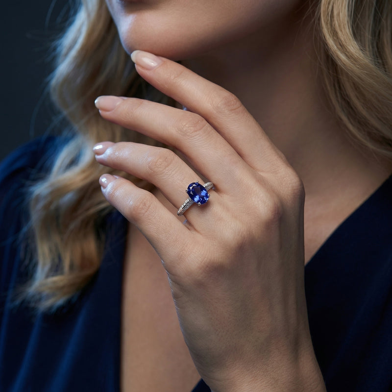 Woman wearing the Novalise oval tanzanite ring in sterling silver on her hand, showcasing the deep blue gemstone.