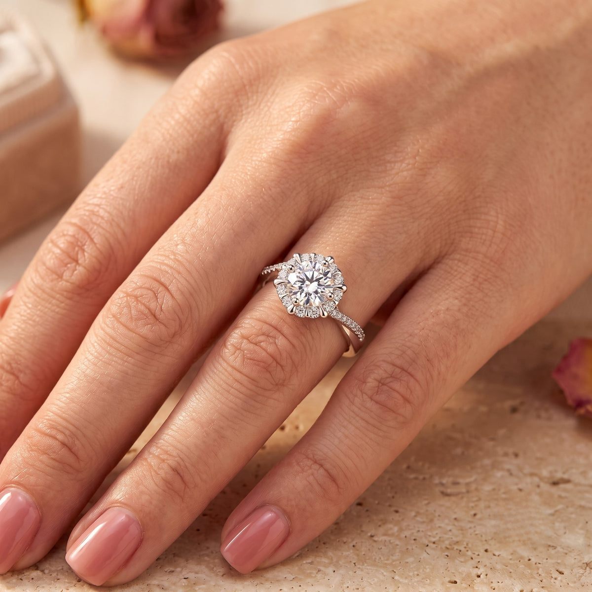 Silver sunburst halo ring with a twisted pavé band worn on a finger.
