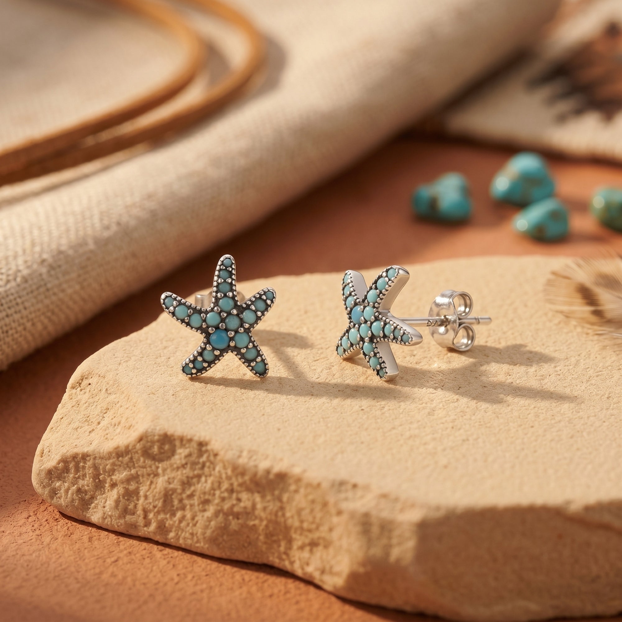 Detail view of sterling silver starfish earrings with turquoise stones, showing the post and butterfly back.