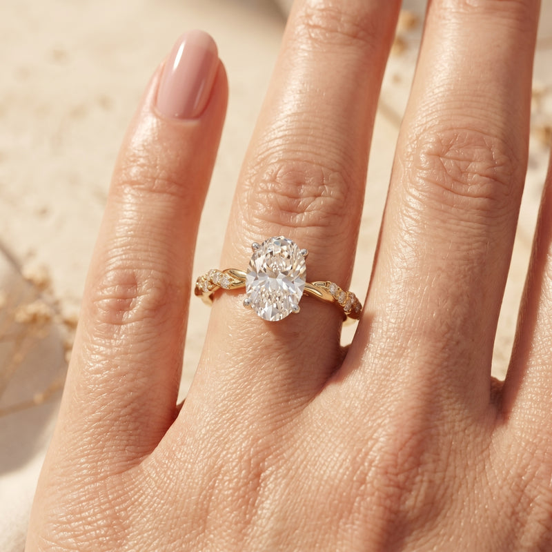 Yellow gold oval moissanite ring on model's finger.