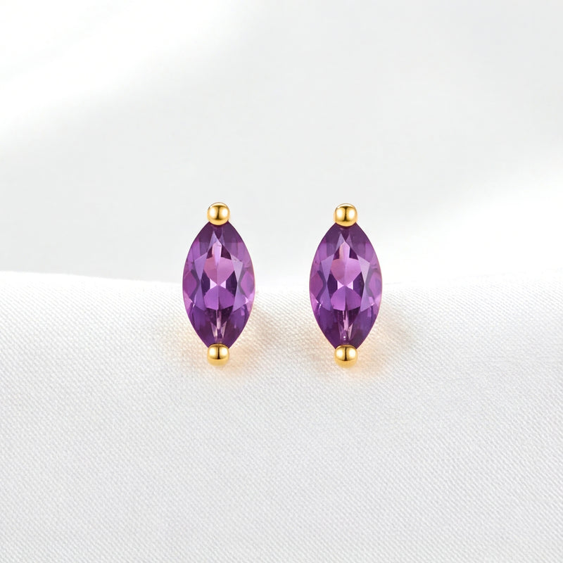 Front view of The Marcella Studs, marquise-cut purple simulated amethyst earrings in 18K gold vermeil on white fabric.