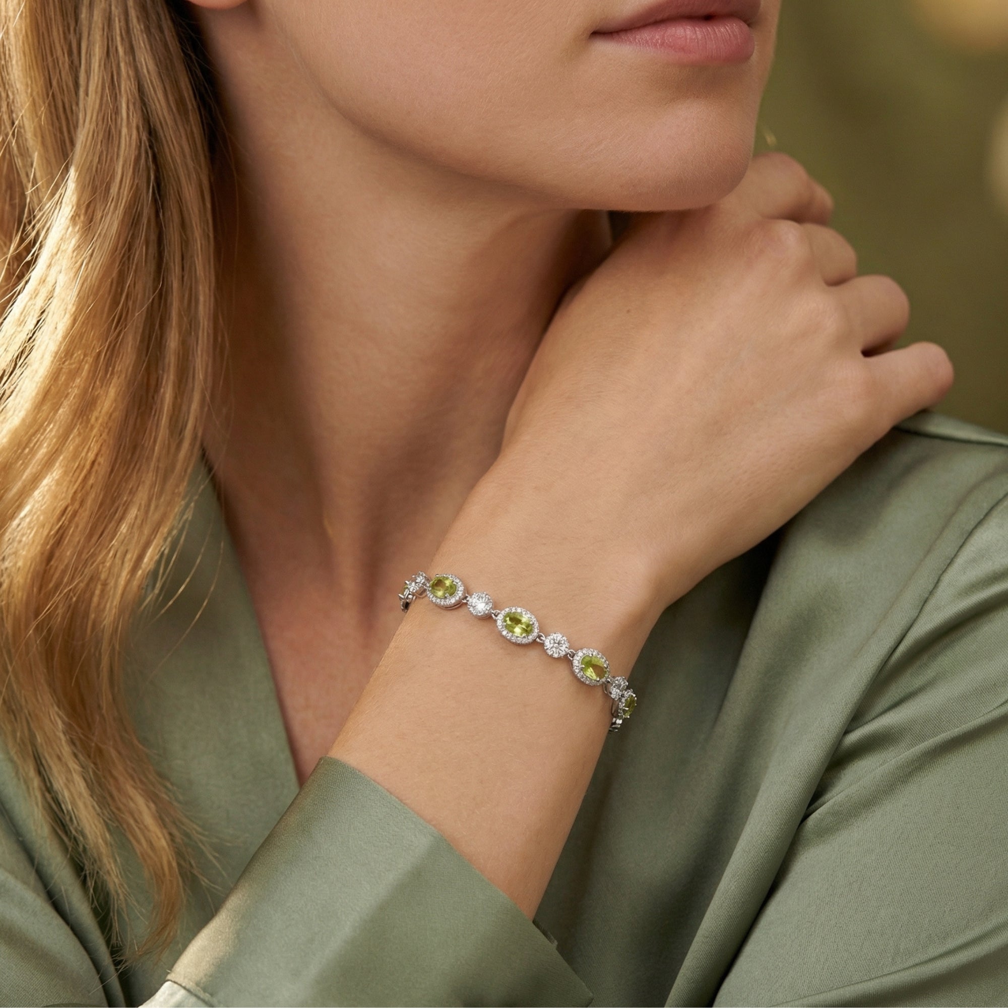 Woman wearing the Calianna S925 sterling silver bracelet featuring oval-cut natural peridot gemstones.