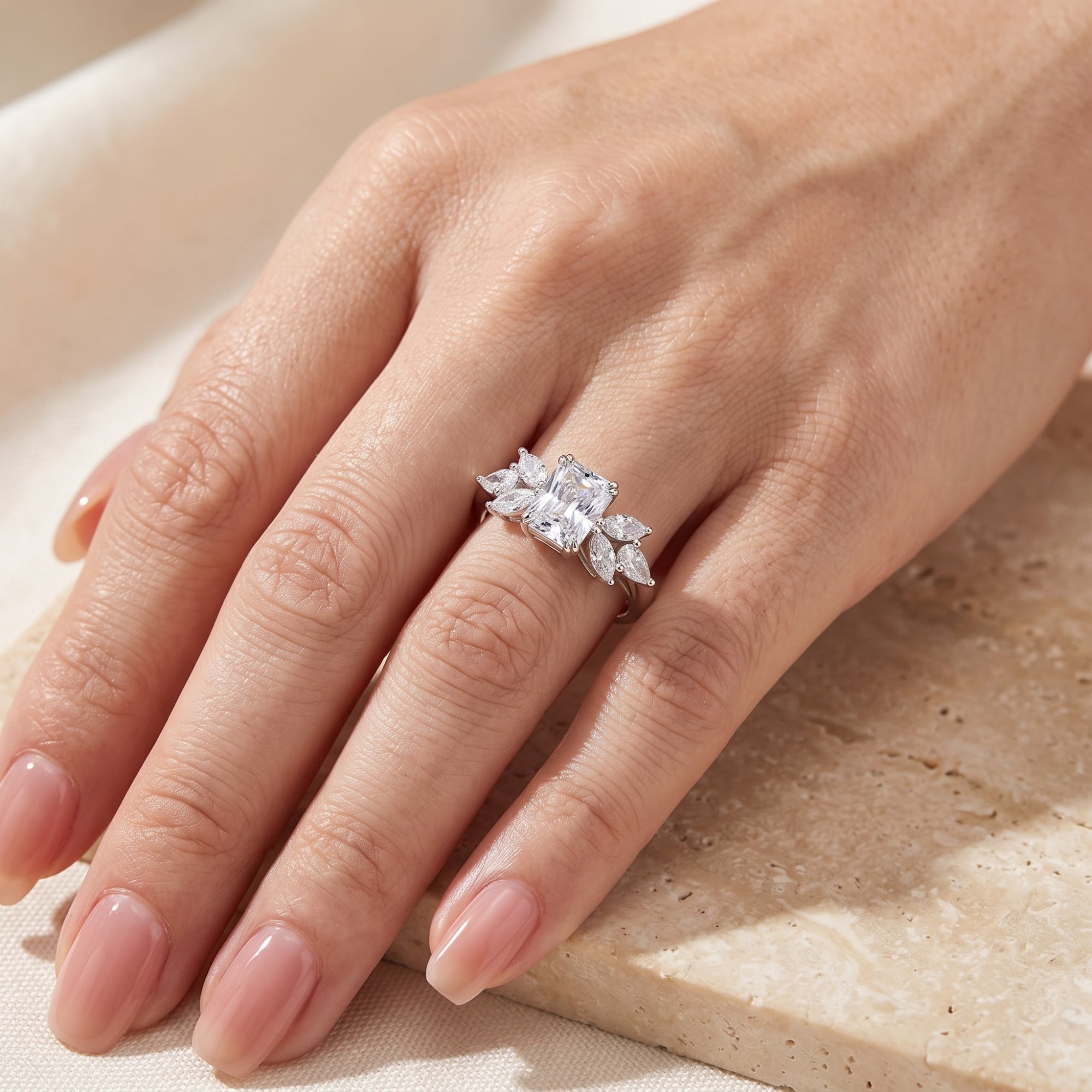 Sterling silver Alandrelle ring with radiant cut simulated diamond worn on a woman's hand.