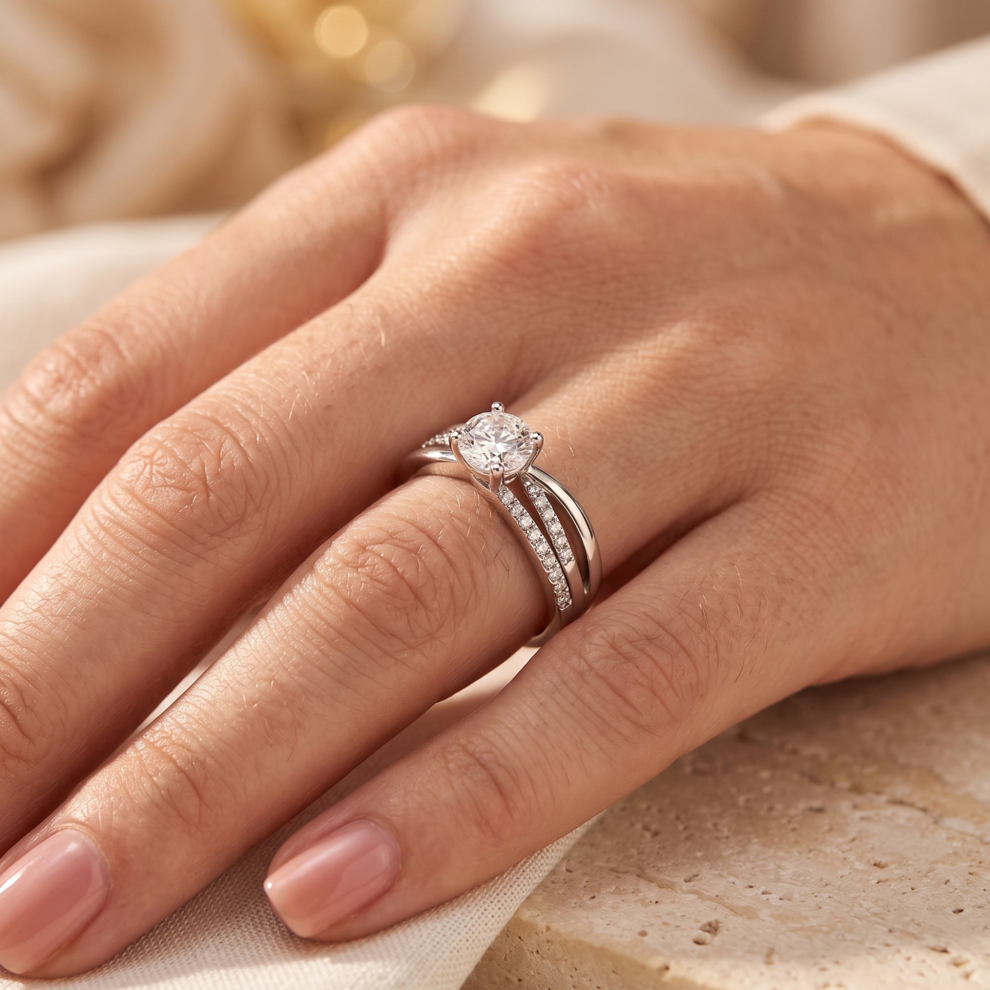Angled view of the sterling silver Donatella crossover ring with a round simulated diamond worn on a finger.