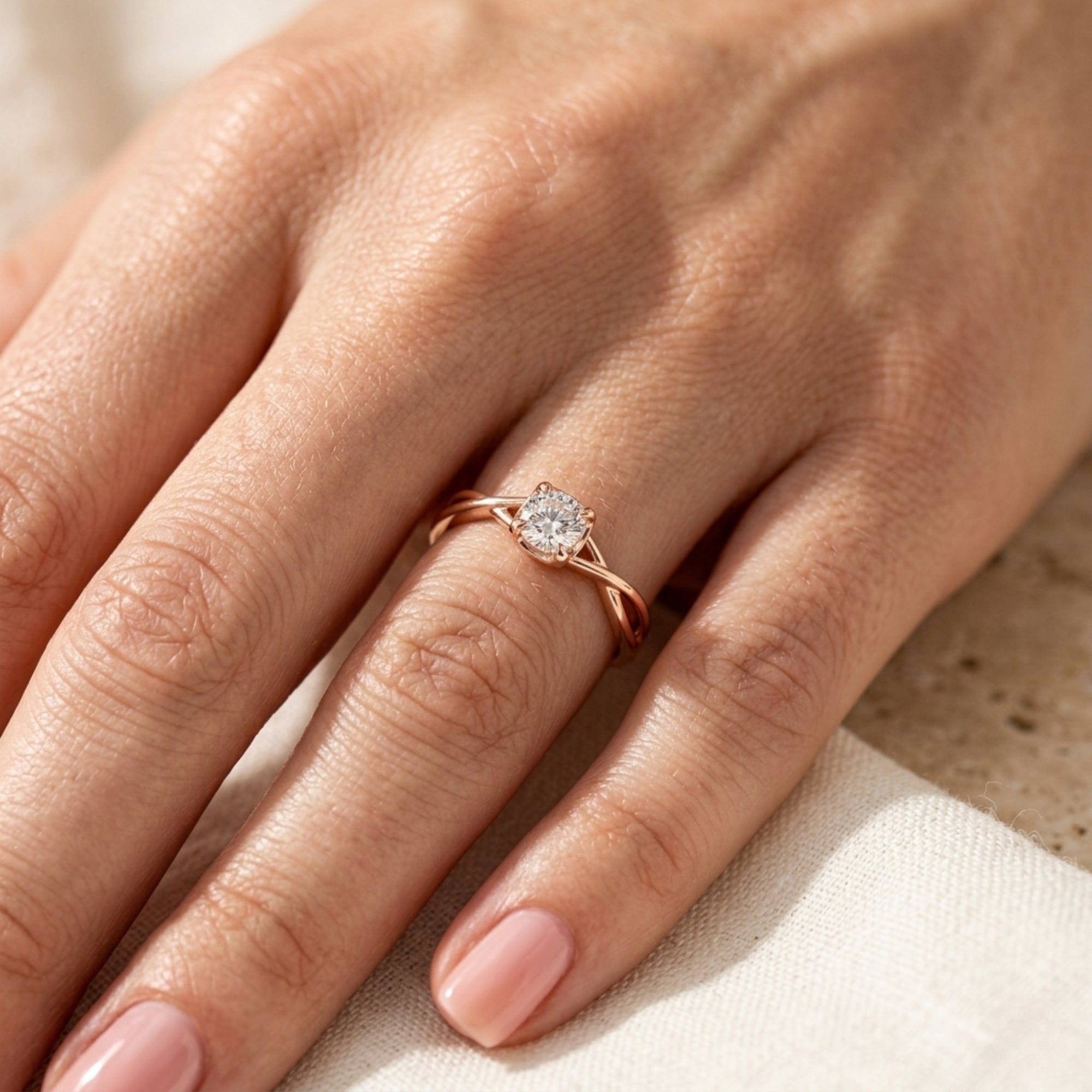 Rose gold promise ring with a round cut moissanite worn on a woman's finger.
