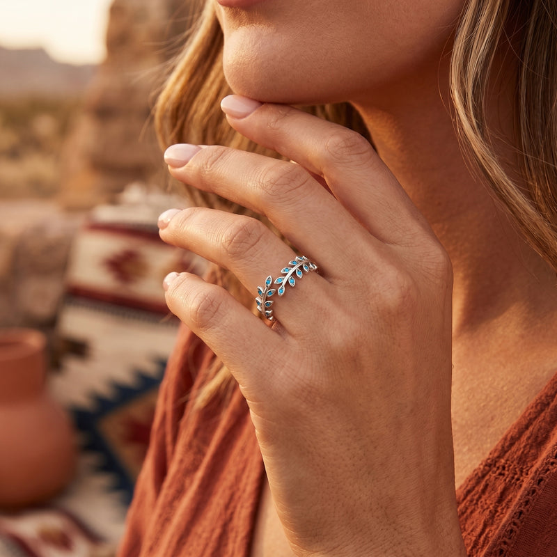 The Arroyo turquoise leaf ring in sterling silver worn on a woman's hand in a desert setting.