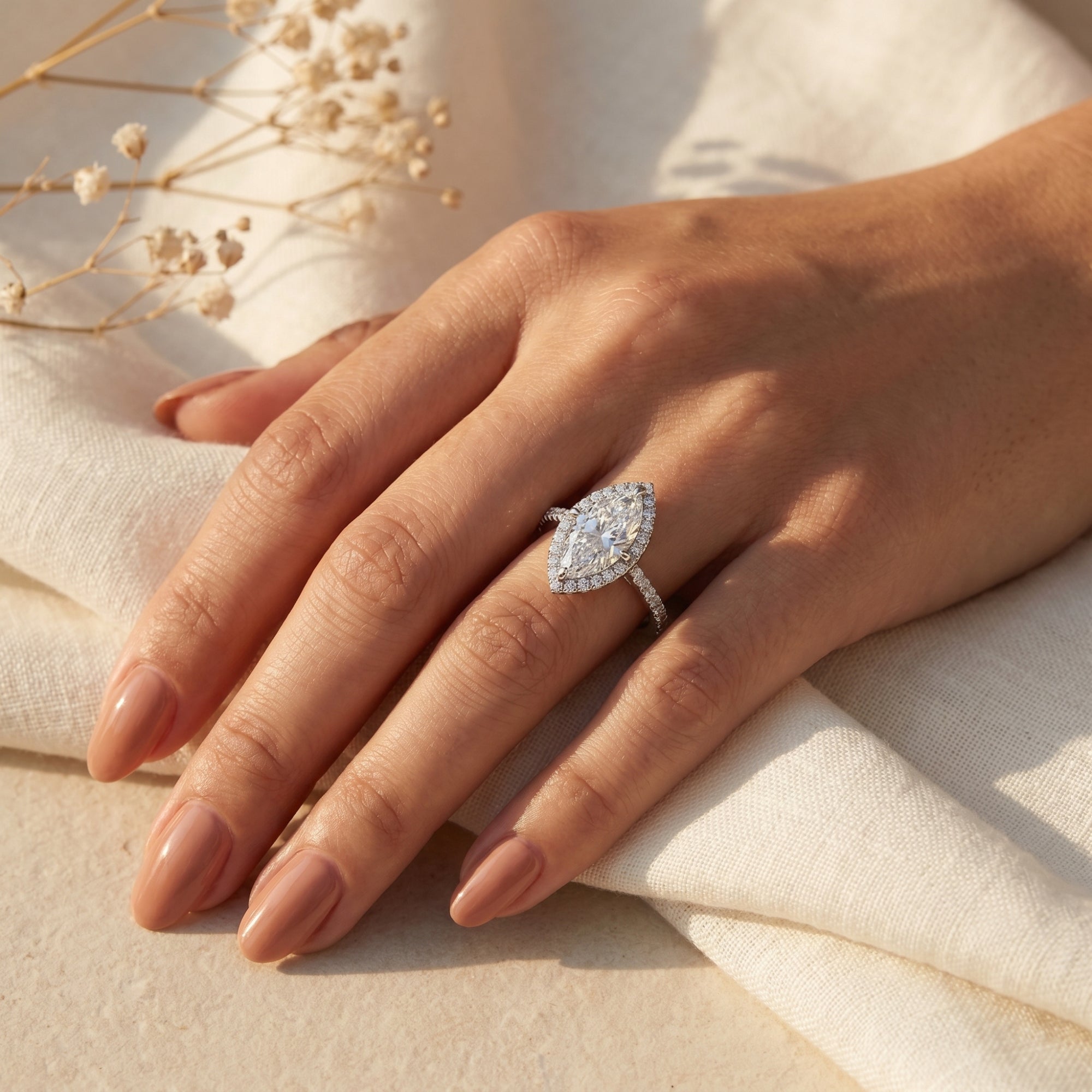 Marquise moissanite halo ring in sterling silver worn on a model's finger.