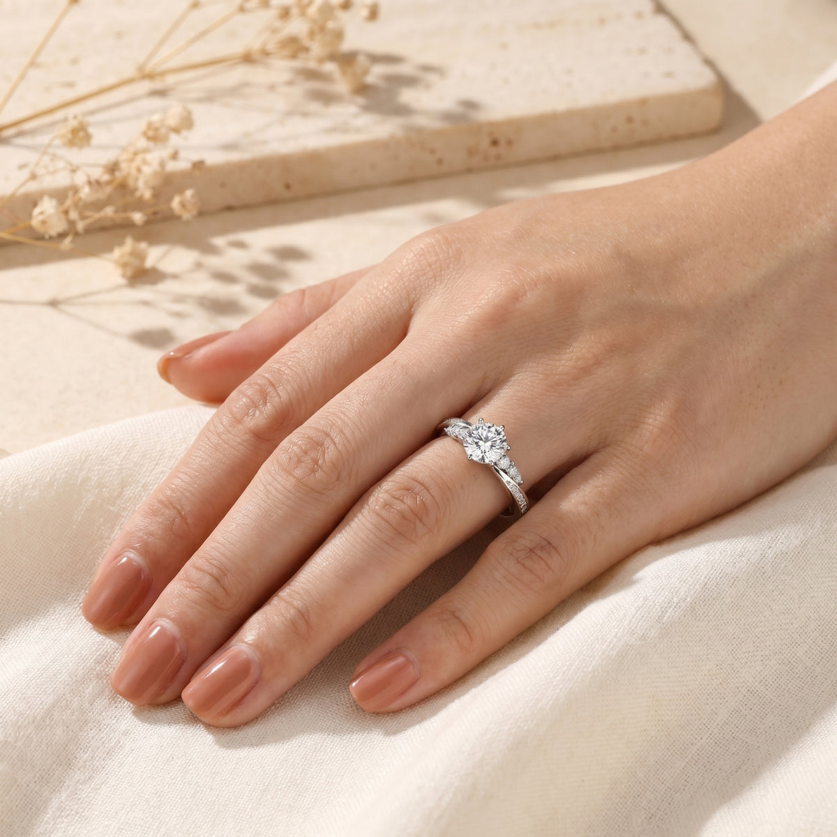 2ct round-cut moissanite engagement ring in sterling silver worn on a woman's hand.