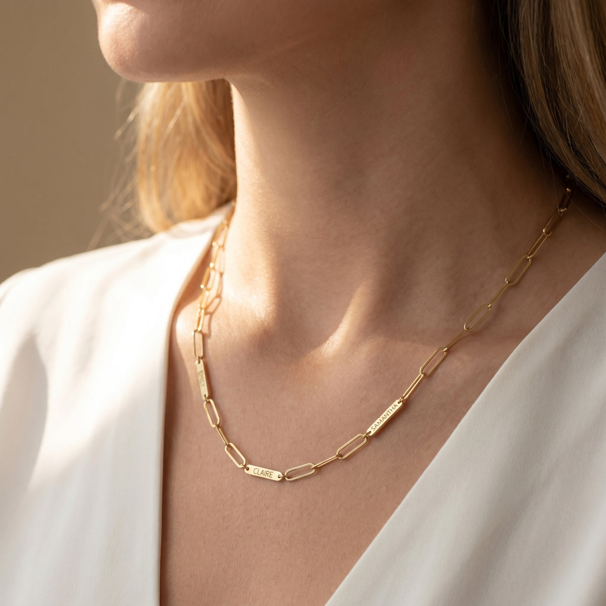 Gold 18K PVD stainless steel paperclip name necklace worn by model.
