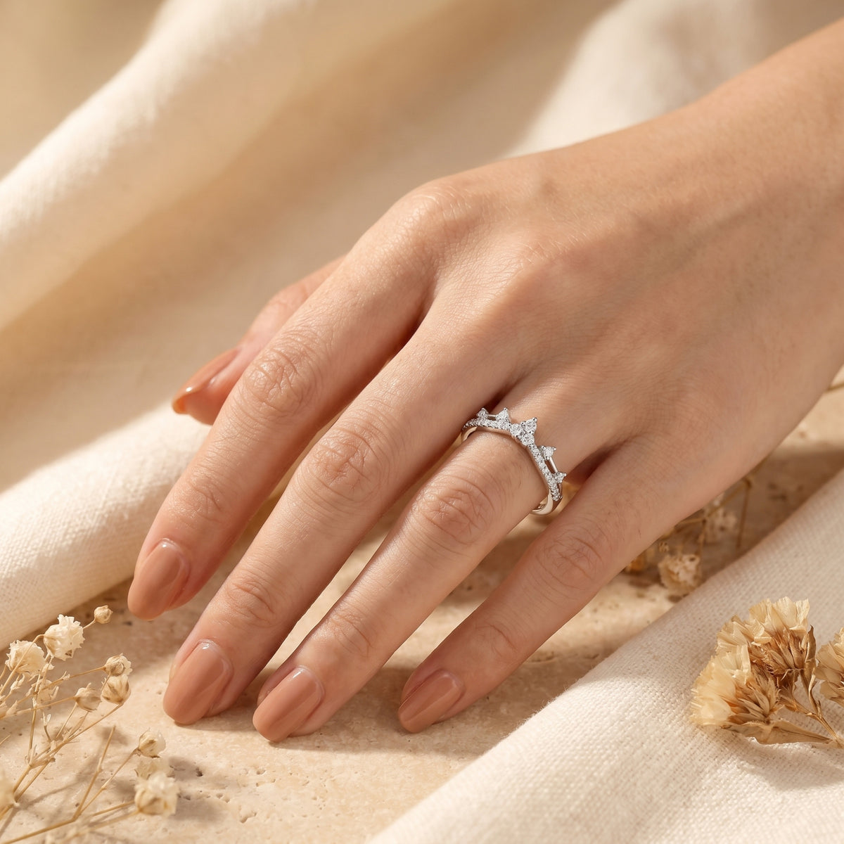 Silver Ismerelle tiara ring with simulated diamonds worn on a model's hand with neutral nail polish.