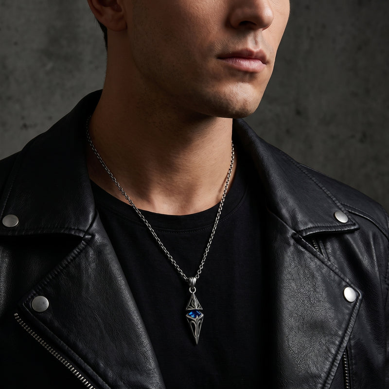 Man wearing the silver pendant necklace with a blue center stone over a black shirt and leather jacket.