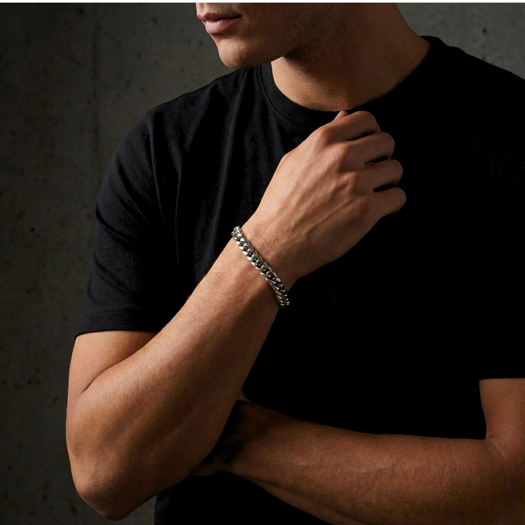Man wearing a silver stainless steel 8mm Cuban link bracelet on his wrist.