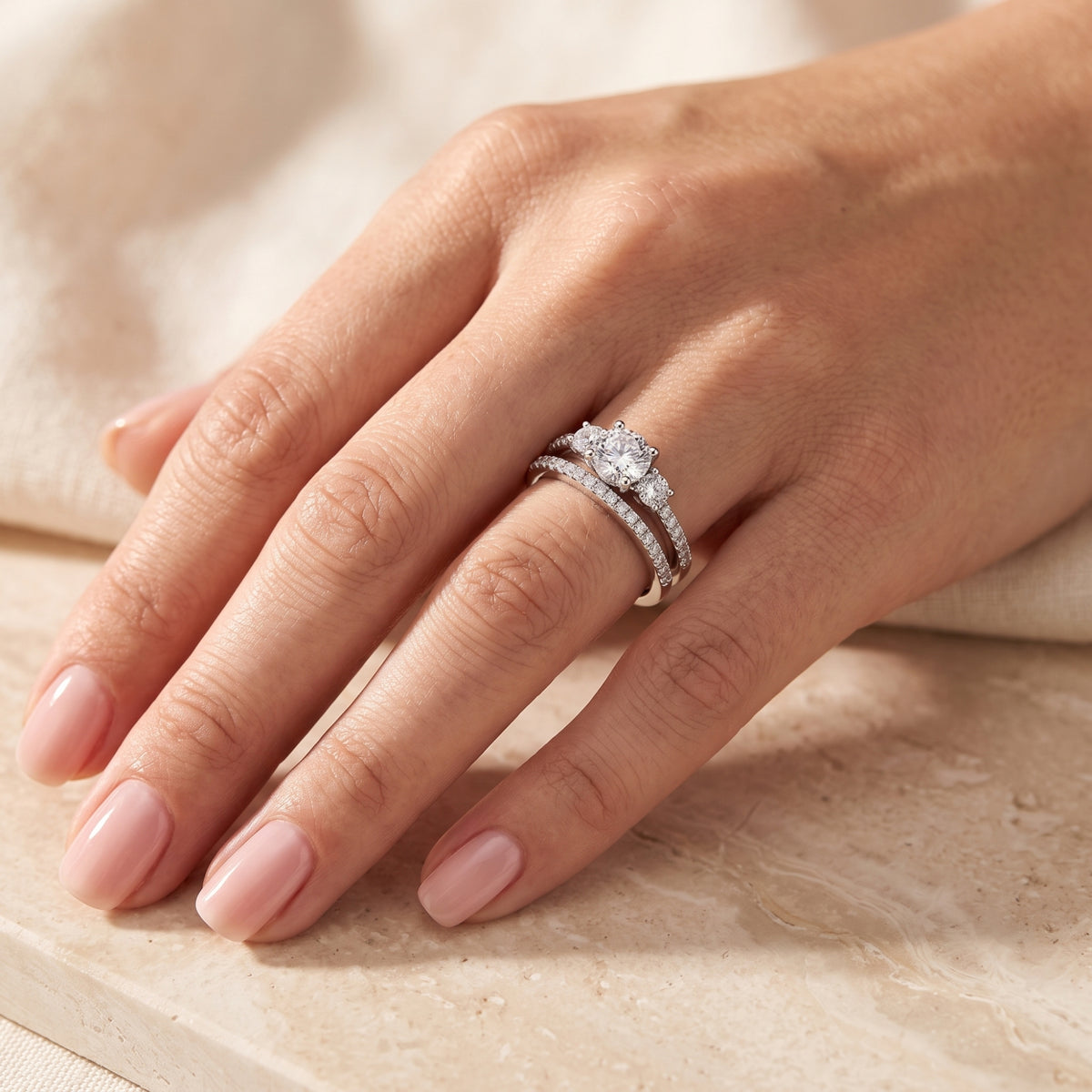 Sterling silver Adalicia ring set featuring round-cut simulated diamonds worn on a woman's hand.