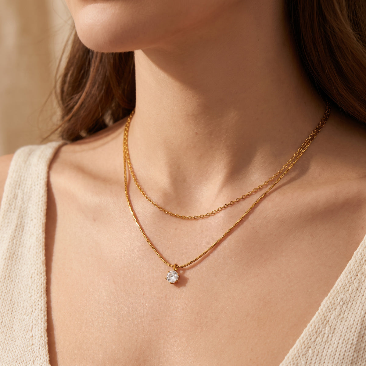 Front close-up of a model wearing the gold-tone double-strand necklace with a round pendant.