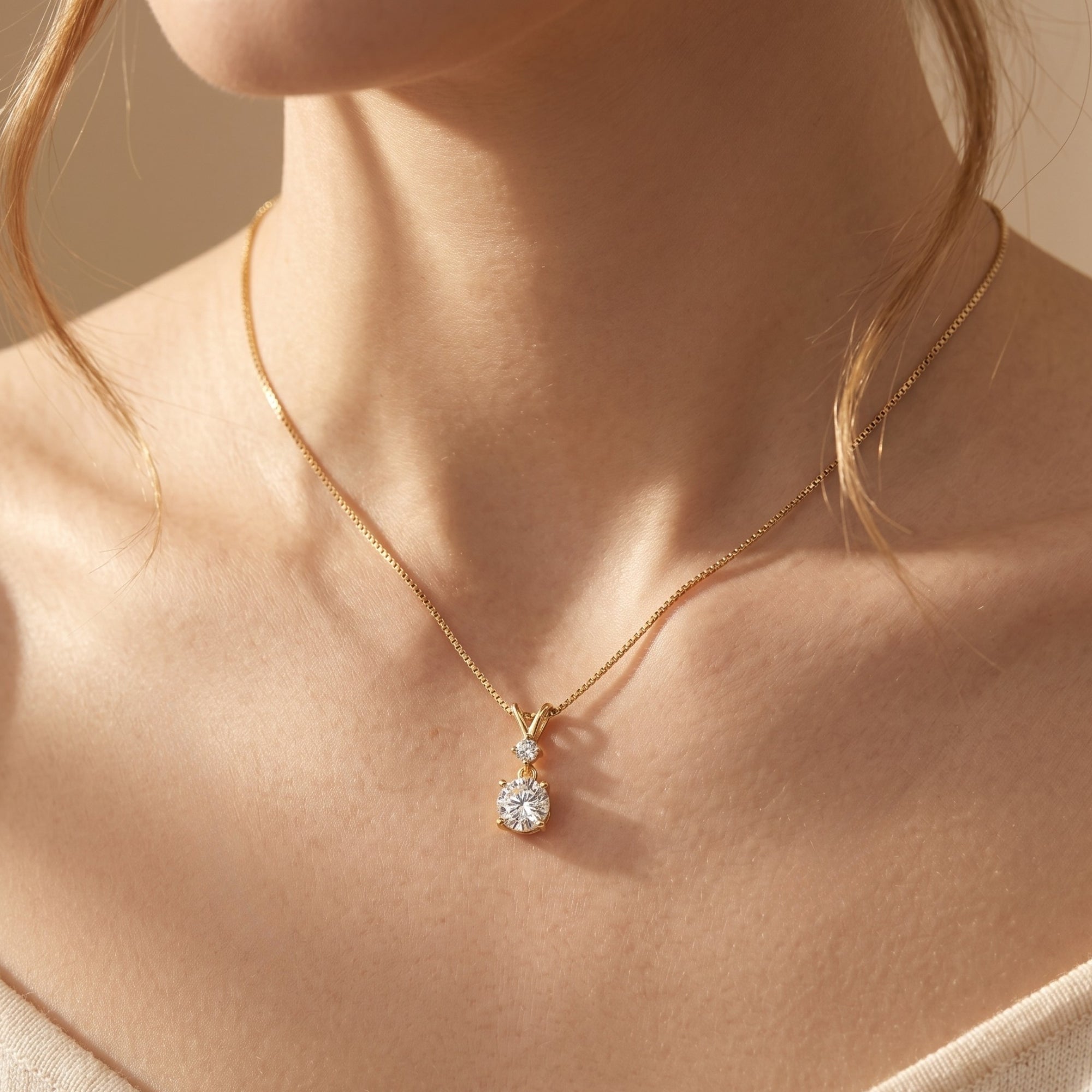 Yellow gold Elyrielle moissanite pendant necklace worn on a woman's neck.