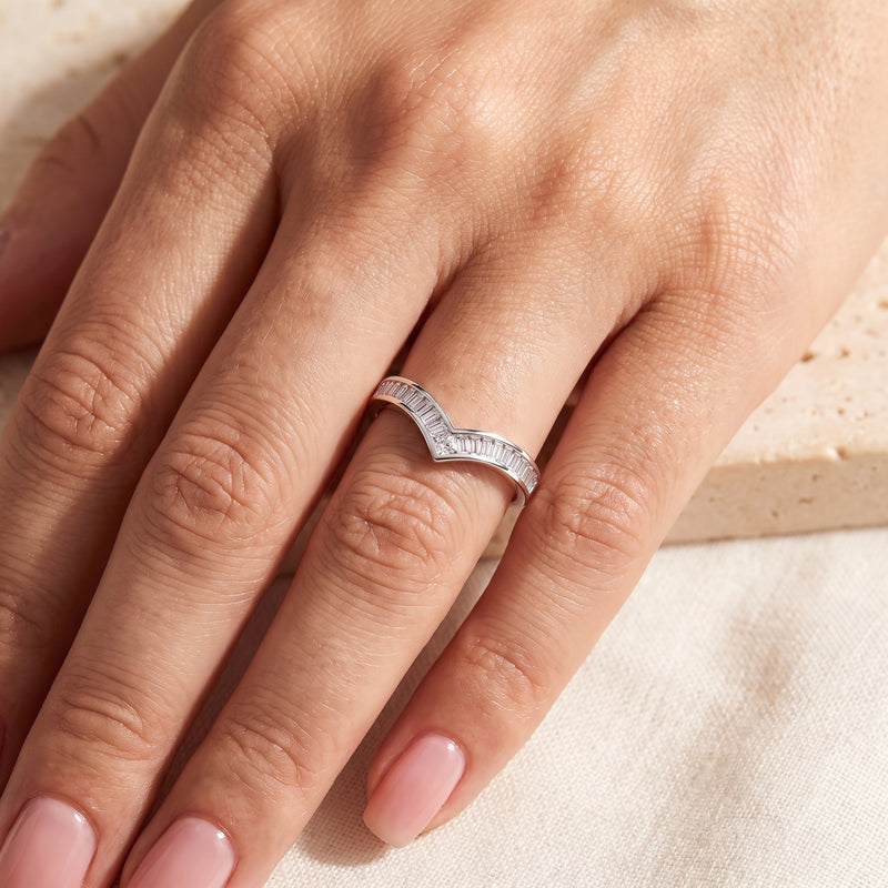 Silver baguette chevron ring worn on a finger with the V-shaped point facing toward the fingertips.