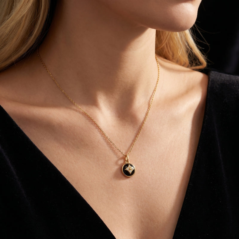 Gold plated Equinox natural onyx pendant necklace worn by a woman with blonde hair and a black top.
