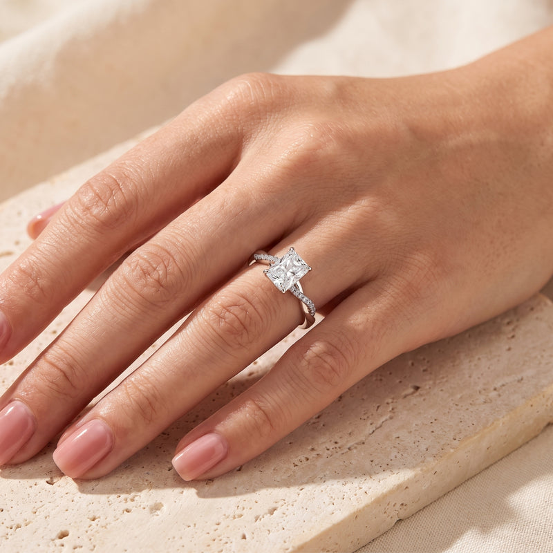 Sterling silver radiant cut simulated diamond ring shown on a hand for scale.