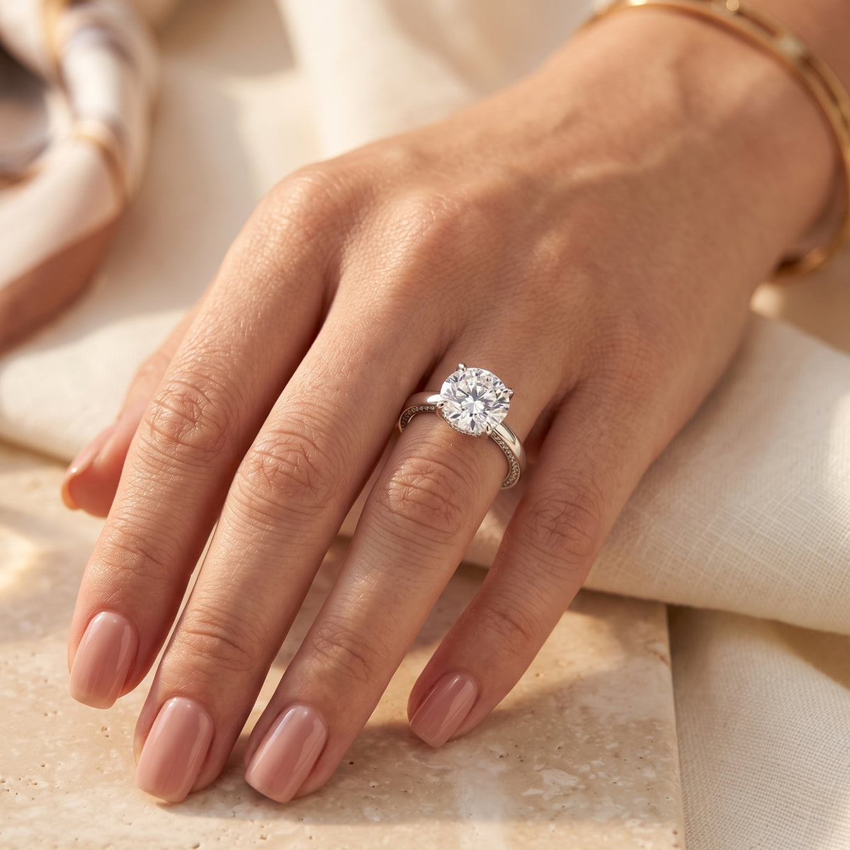 The Iselienne round-cut simulated diamond solitaire ring in sterling silver worn on a woman's hand.