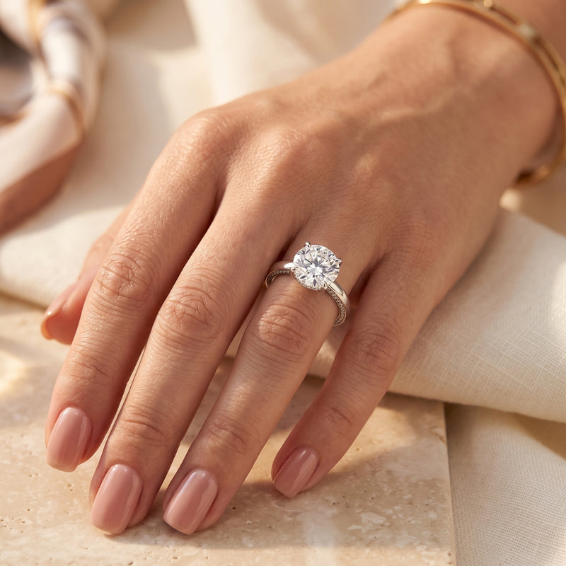 The Iselienne round-cut simulated diamond solitaire ring in sterling silver worn on a woman's hand.