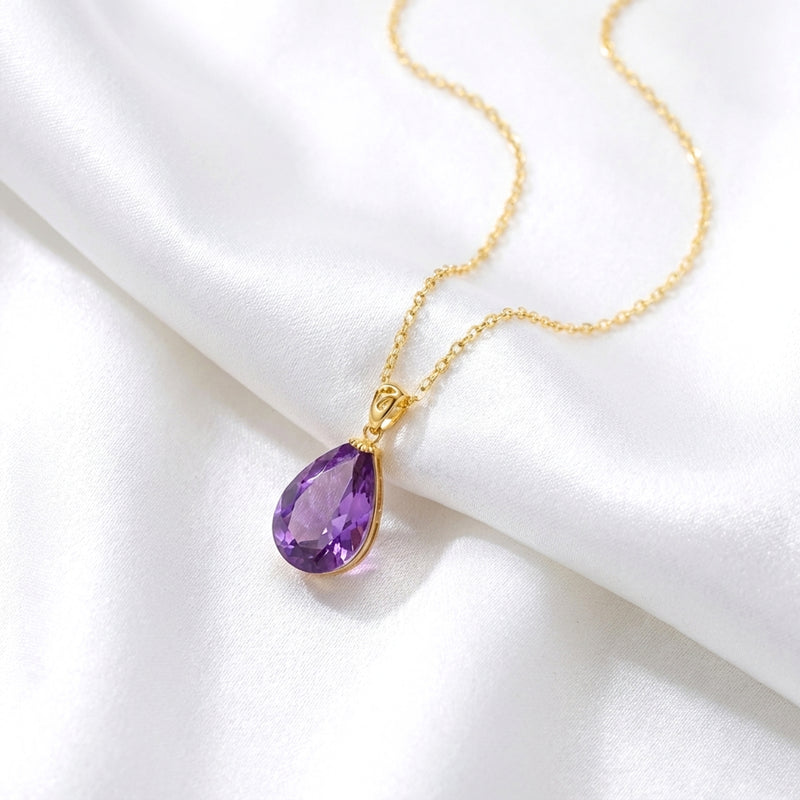 The Vesperia teardrop simulated amethyst necklace in 18K gold vermeil resting on white silk.