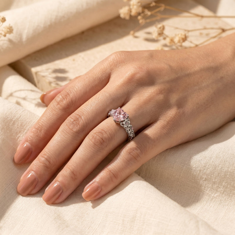 Heart-cut pink diamond silver ring on a woman's hand.