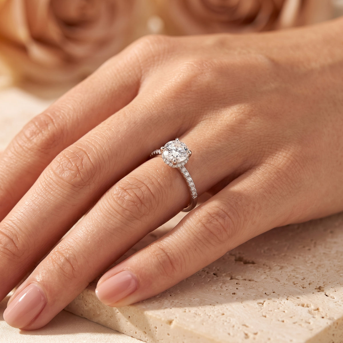 The Elorina simulated diamond ring in sterling silver worn on a woman's hand, showcasing its brilliant round center stone.