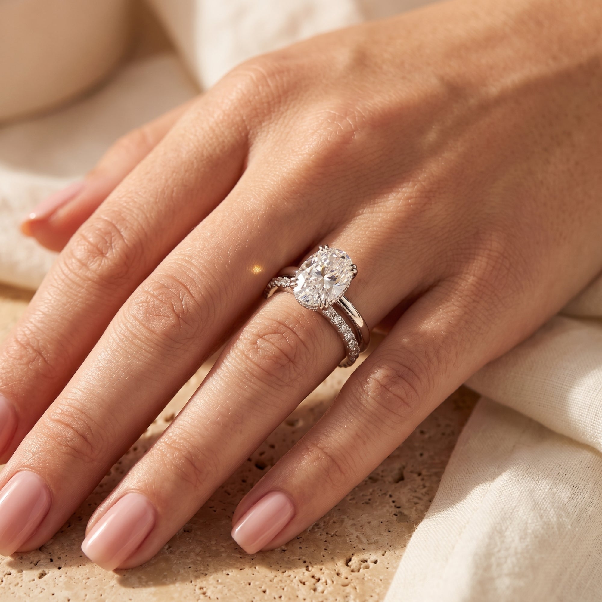 Sterling silver oval-cut simulated diamond bridal set worn on a finger.