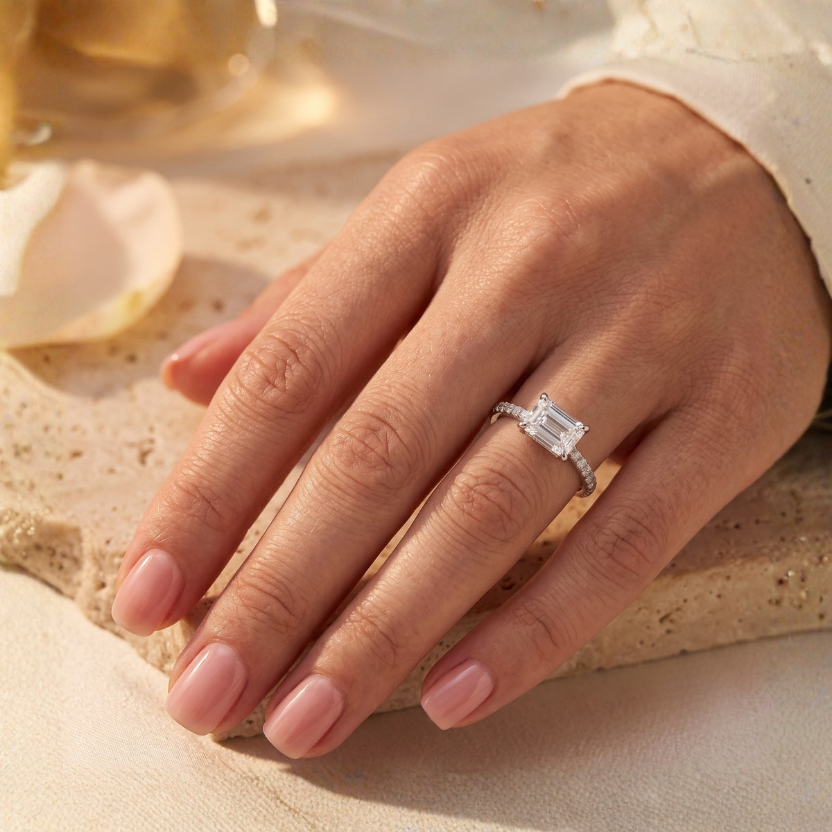 Silver Sarielle East-West ring with an emerald-cut simulated diamond worn on a woman's hand.