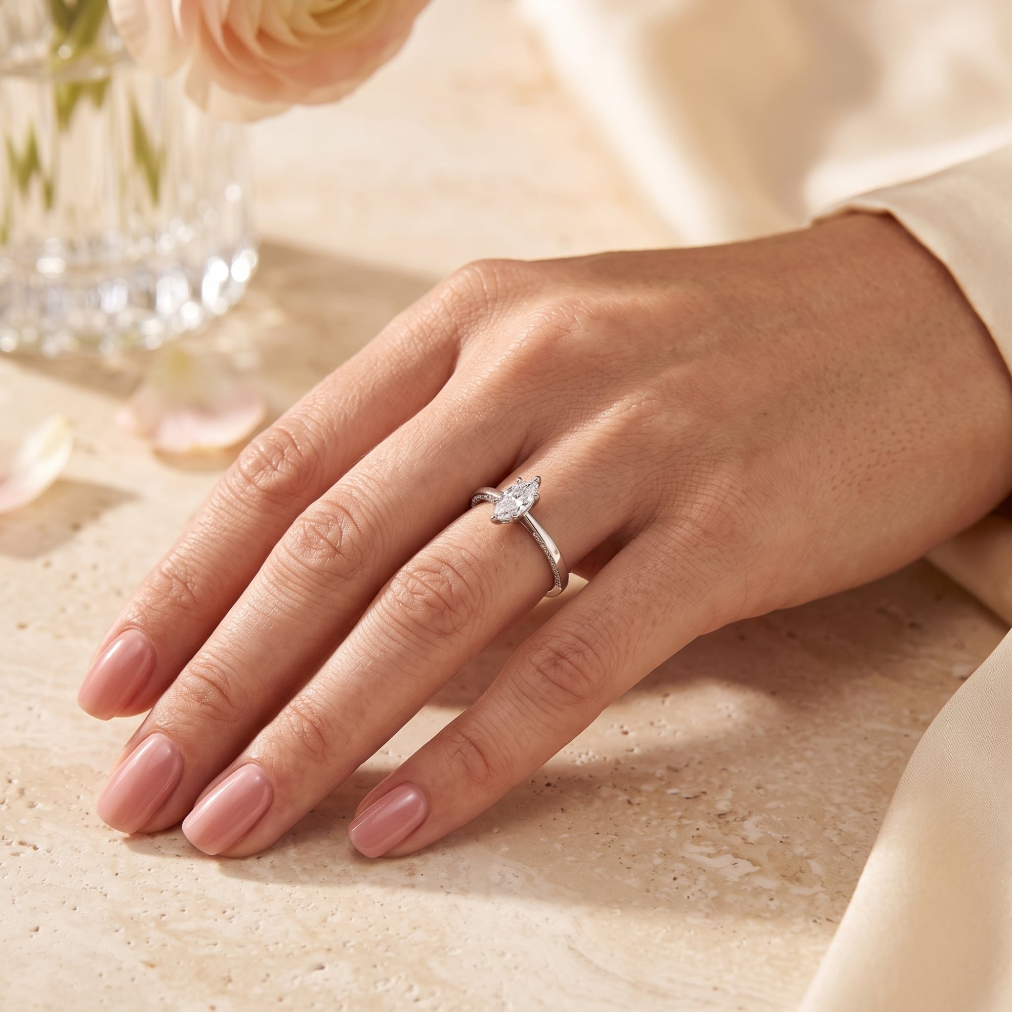 Marquise-cut simulated diamond sterling silver ring worn on a woman's hand with neutral nail polish.