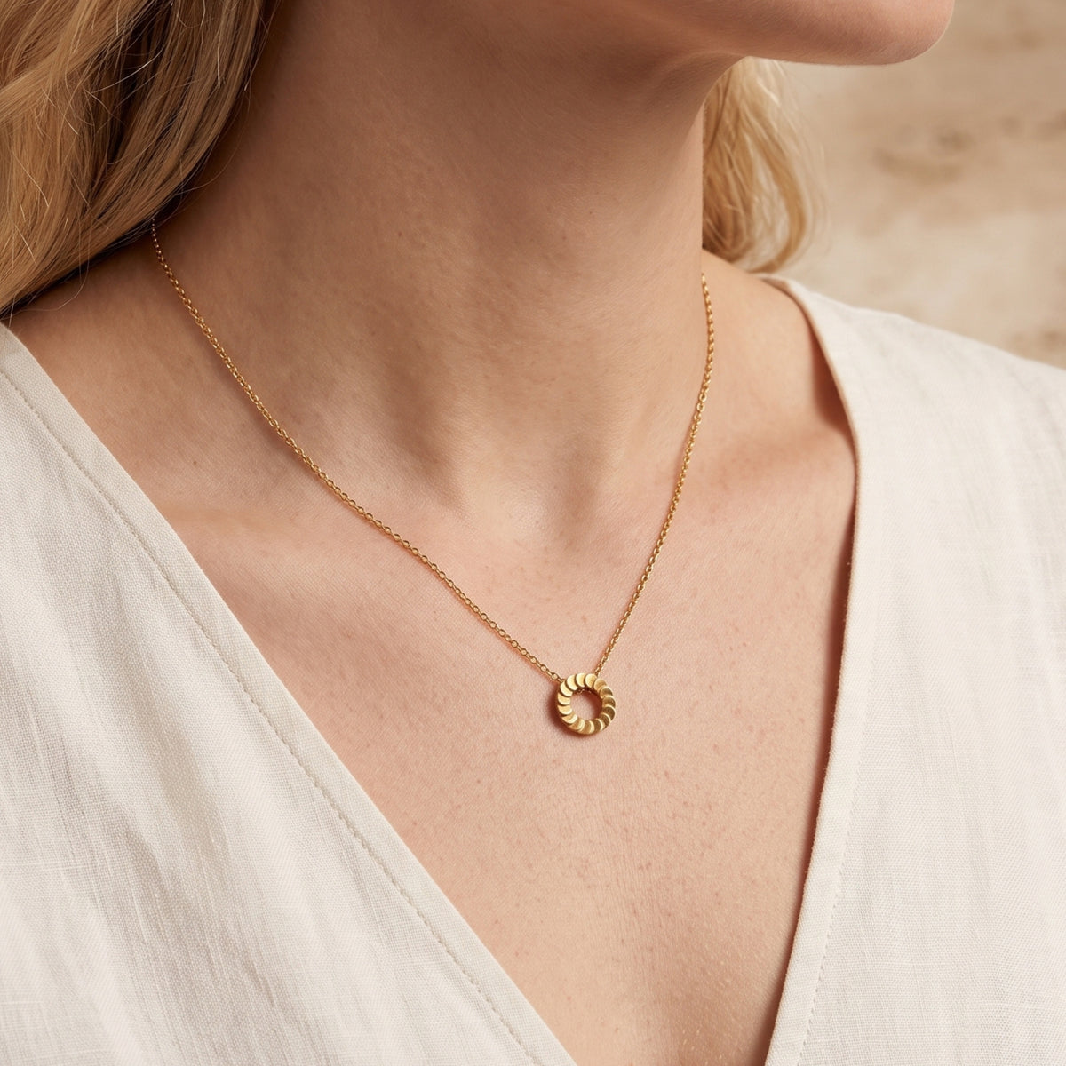 Freya 18K gold plated pendant necklace worn by a model in a white top.