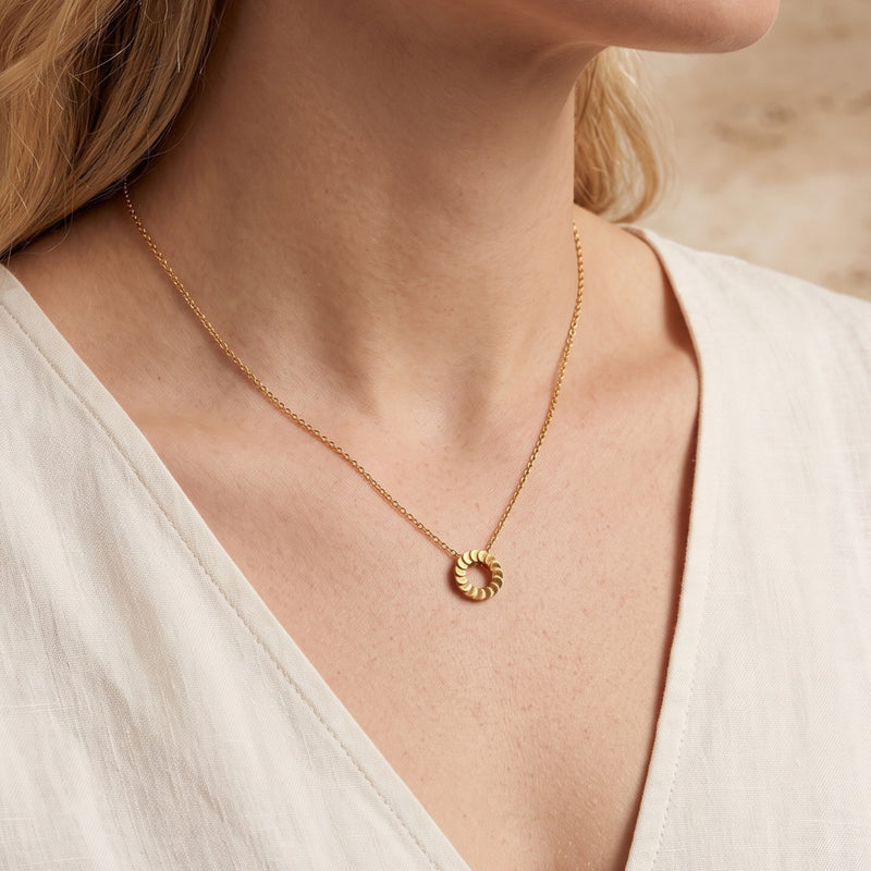 Freya 18K gold plated pendant necklace worn by a model in a white top.