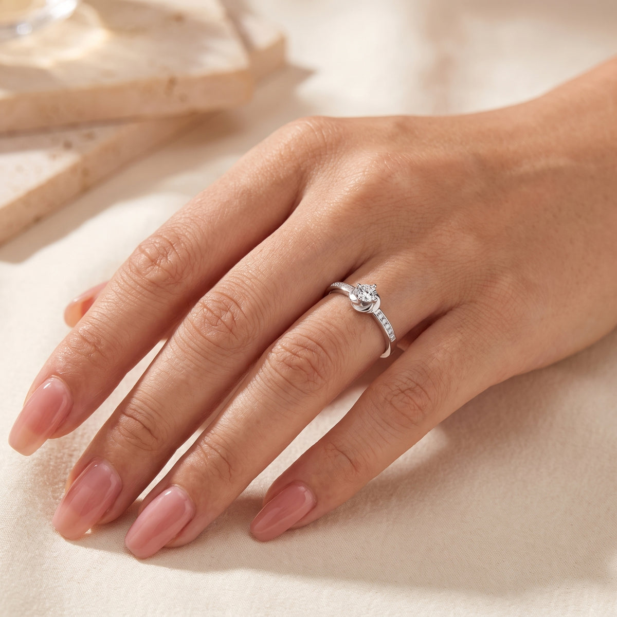 Sterling silver Melisande ring with a round-cut simulated diamond worn on a woman's hand.