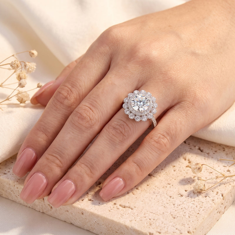 The Elysetta sterling silver ring with a round simulated diamond halo worn on a woman's hand.
