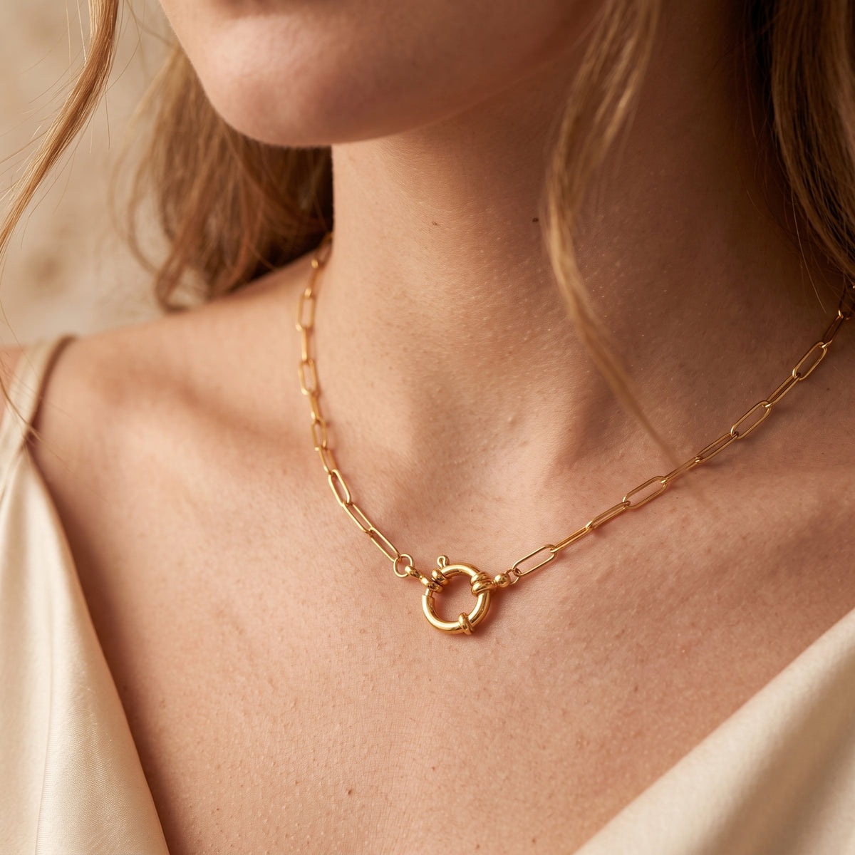 Front view of a model wearing the gold-tone paperclip necklace with central sailor lock clasp.