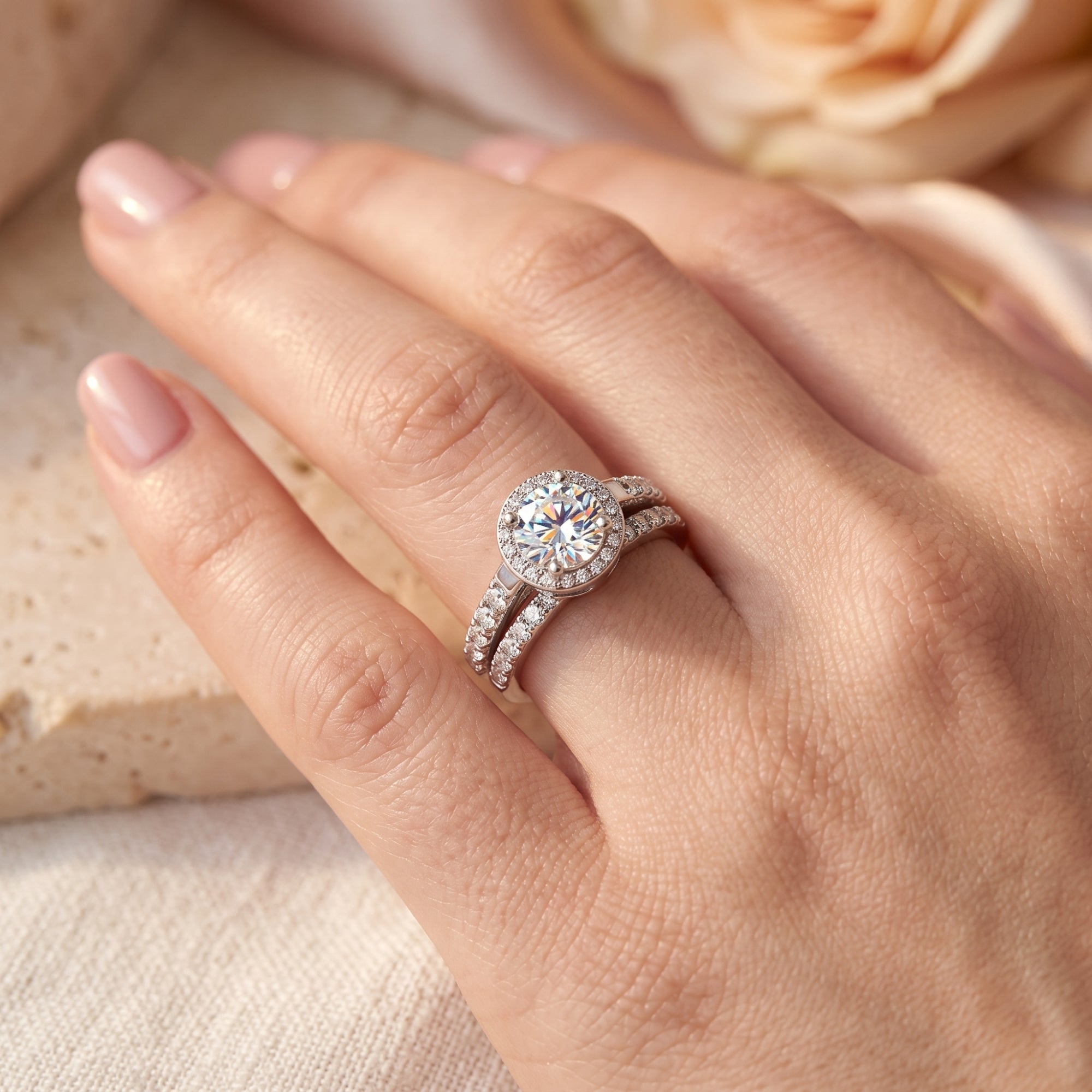 Round cut simulated diamond halo ring set in S925 sterling silver worn on a woman's finger.