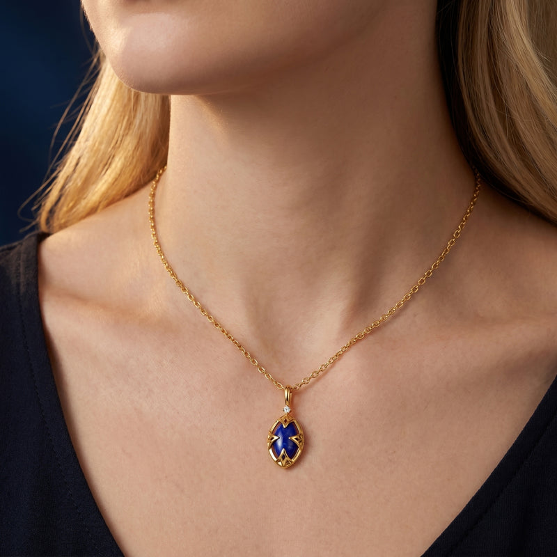 Yellow gold marquise natural lapis lazuli necklace worn by a model against a dark top.