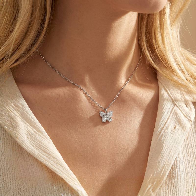 Woman wearing the silver Larabelle moissanite butterfly necklace on a delicate chain.