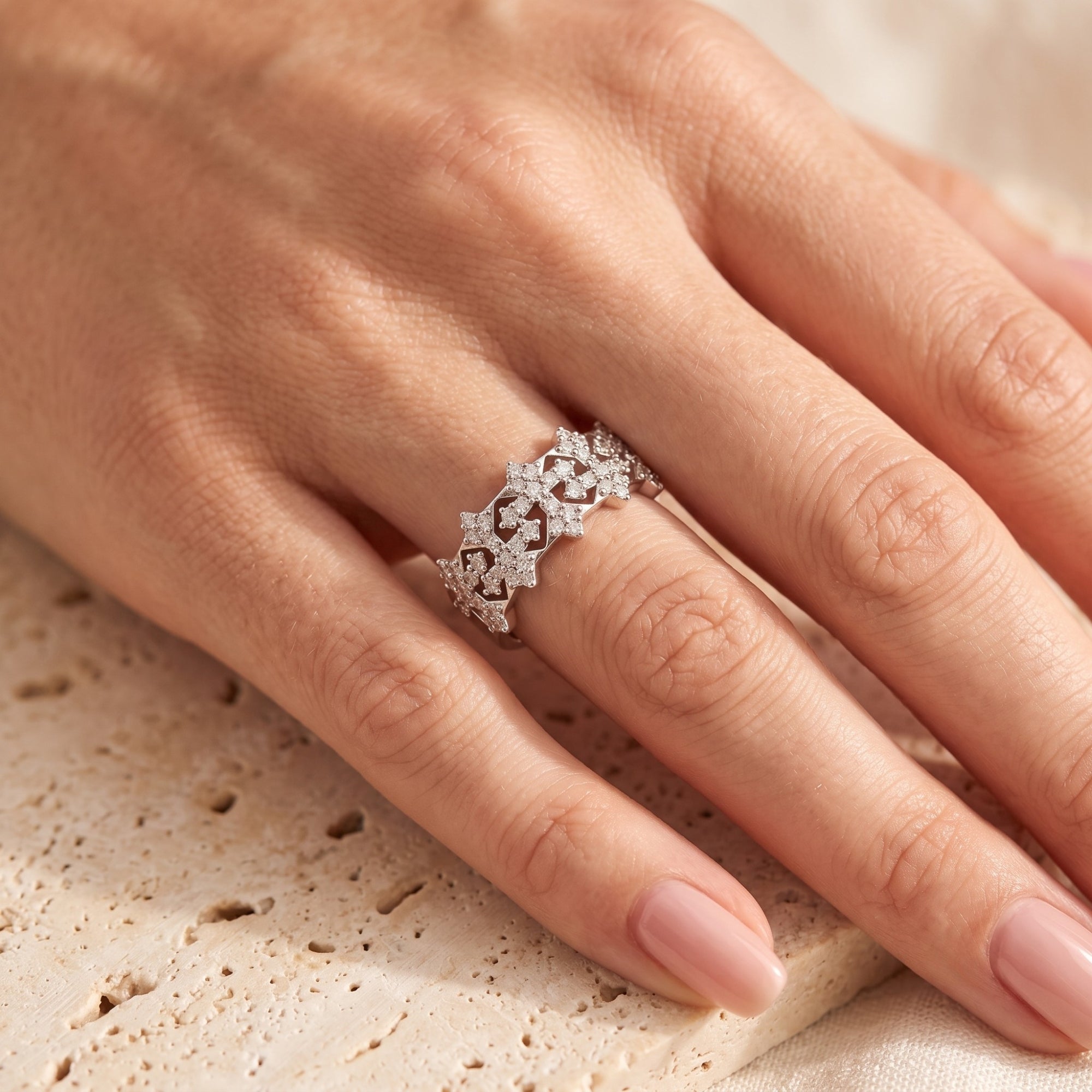 Sterling silver snowflake crown ring with simulated diamonds worn on a finger.