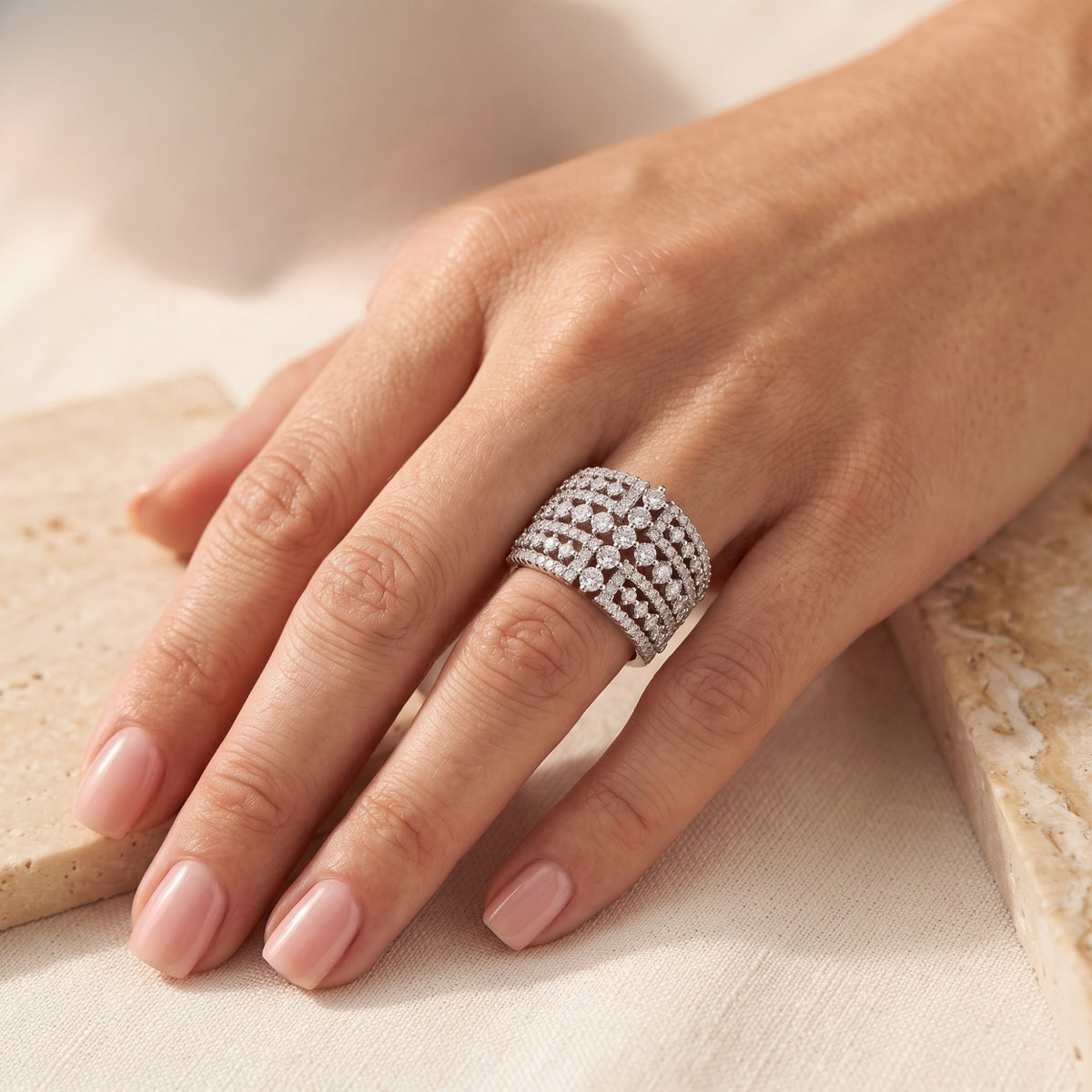 Wide sterling silver multi-row simulated diamond ring worn on a woman's hand.