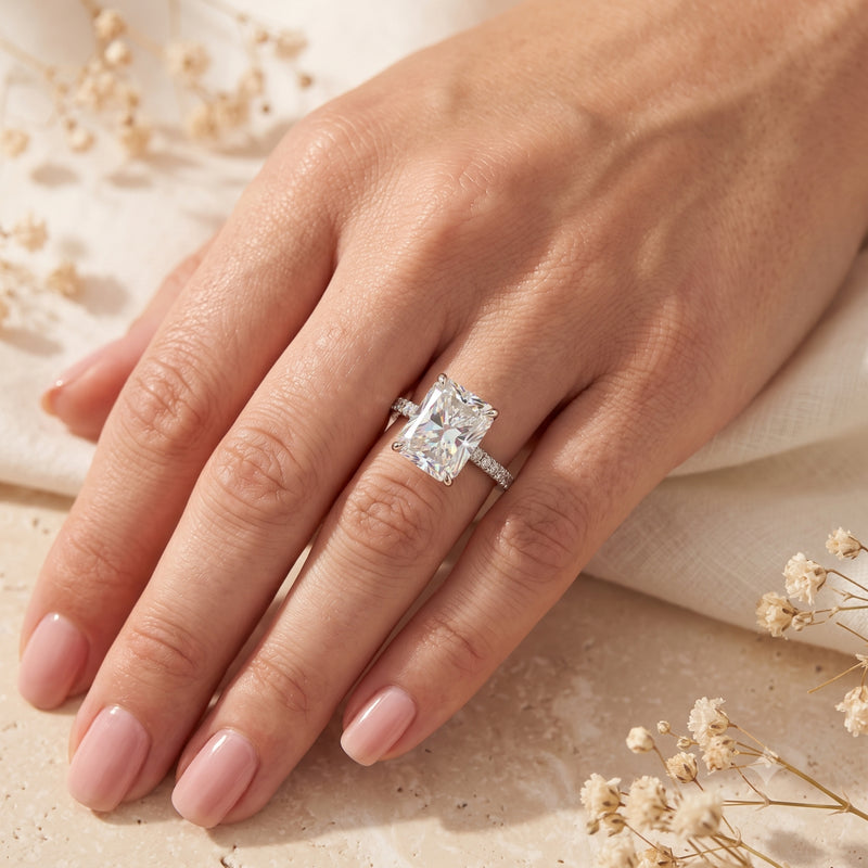 Top view of the Claudette radiant-cut simulated diamond promise ring in sterling silver, worn on a woman's hand.