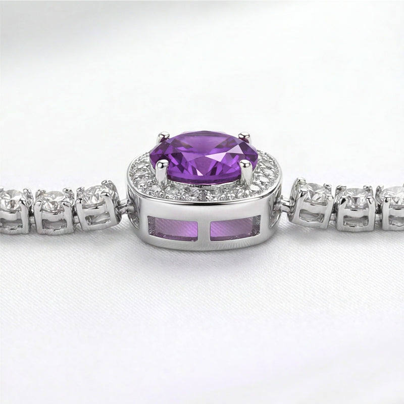 Macro view of a round cut purple simulated amethyst in a sterling silver halo setting with side gallery detail.