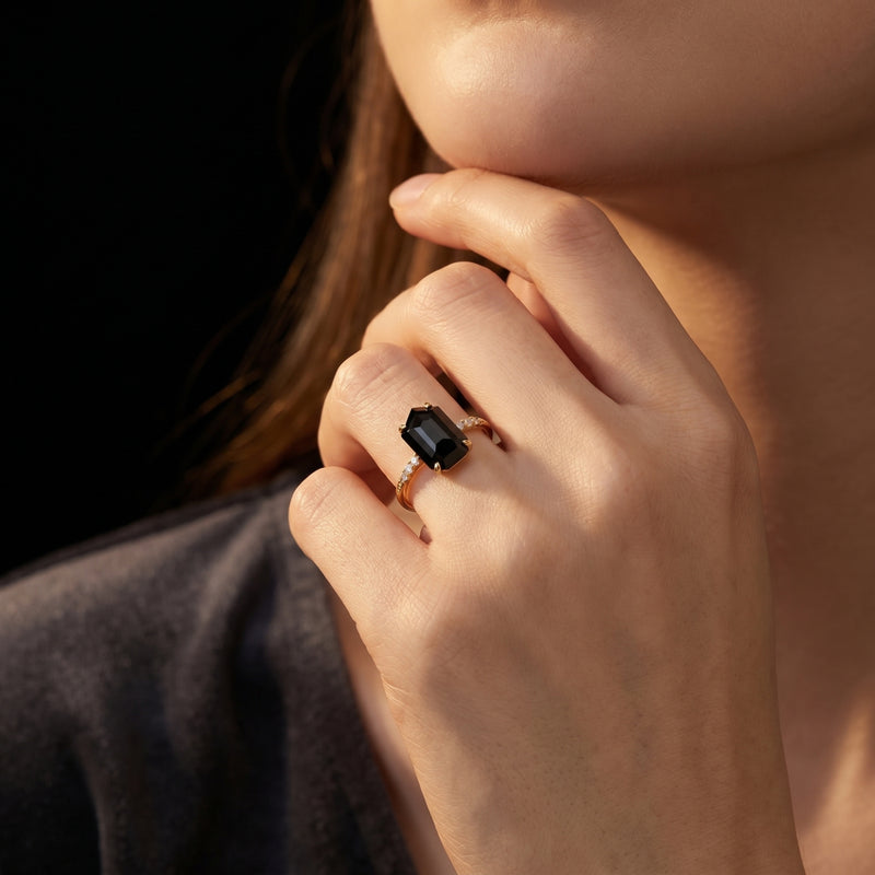 Woman wearing the Noctura natural onyx statement ring with zircon accents in solid gold on her finger.