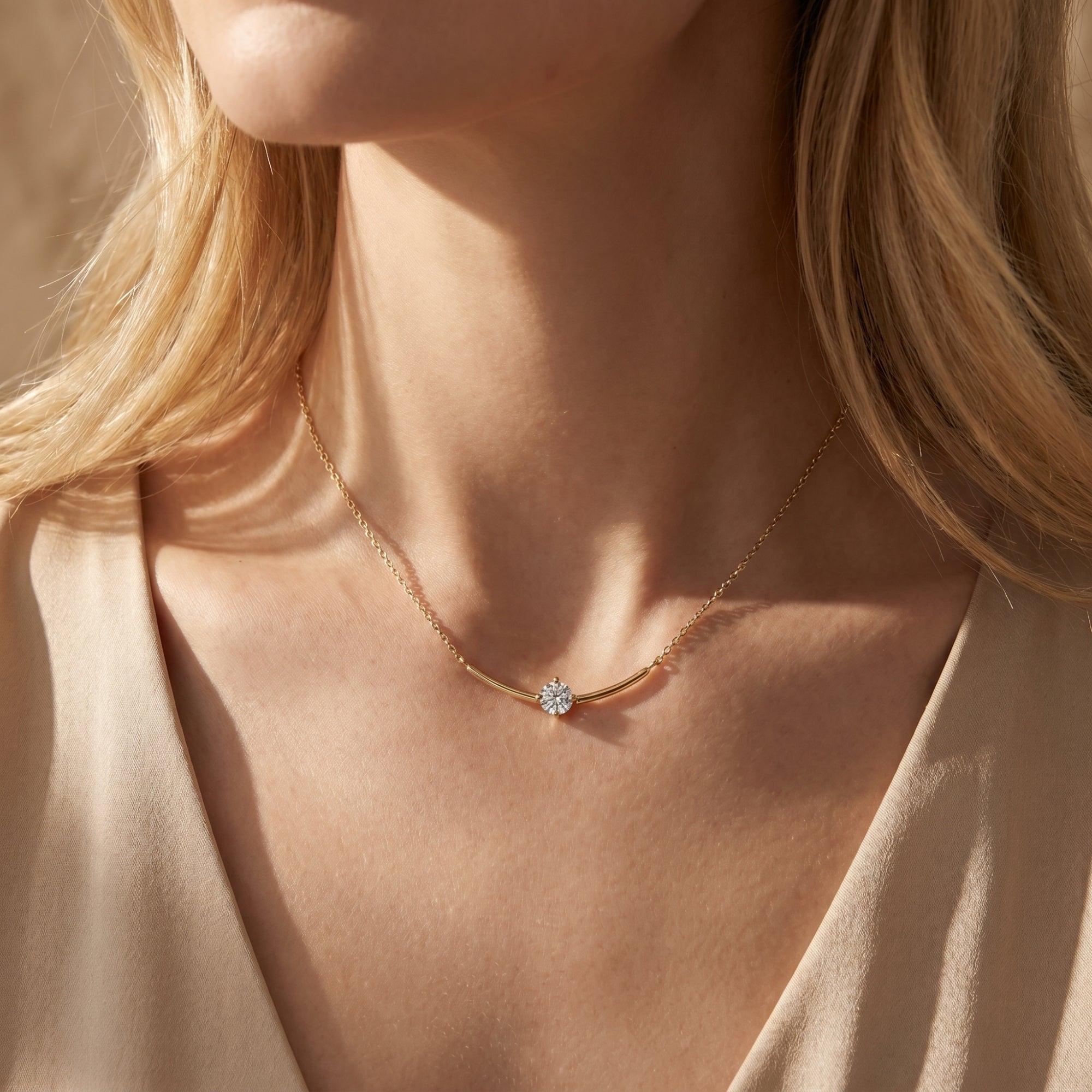 Woman wearing the gold Elionara moissanite pendant necklace with a curved bar setting.