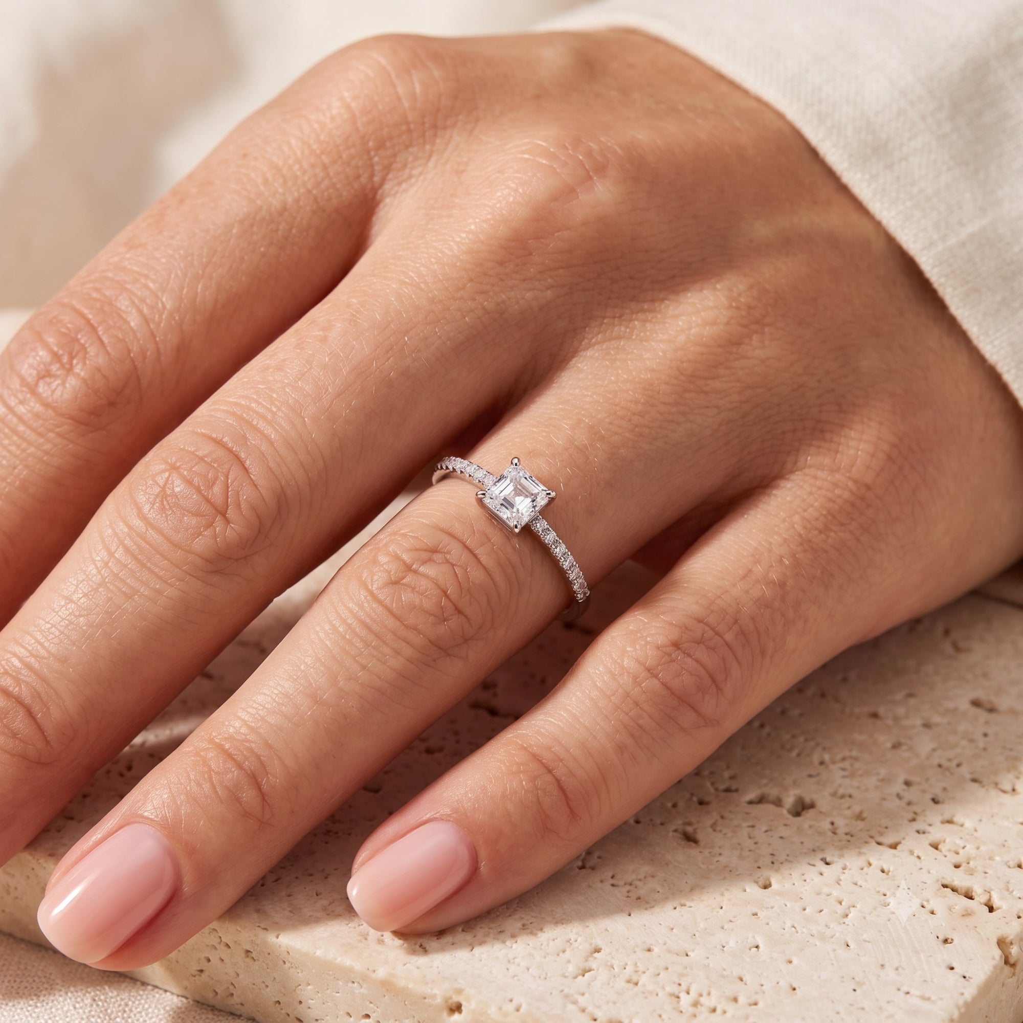 Princess cut CZ silver promise ring worn on a finger.