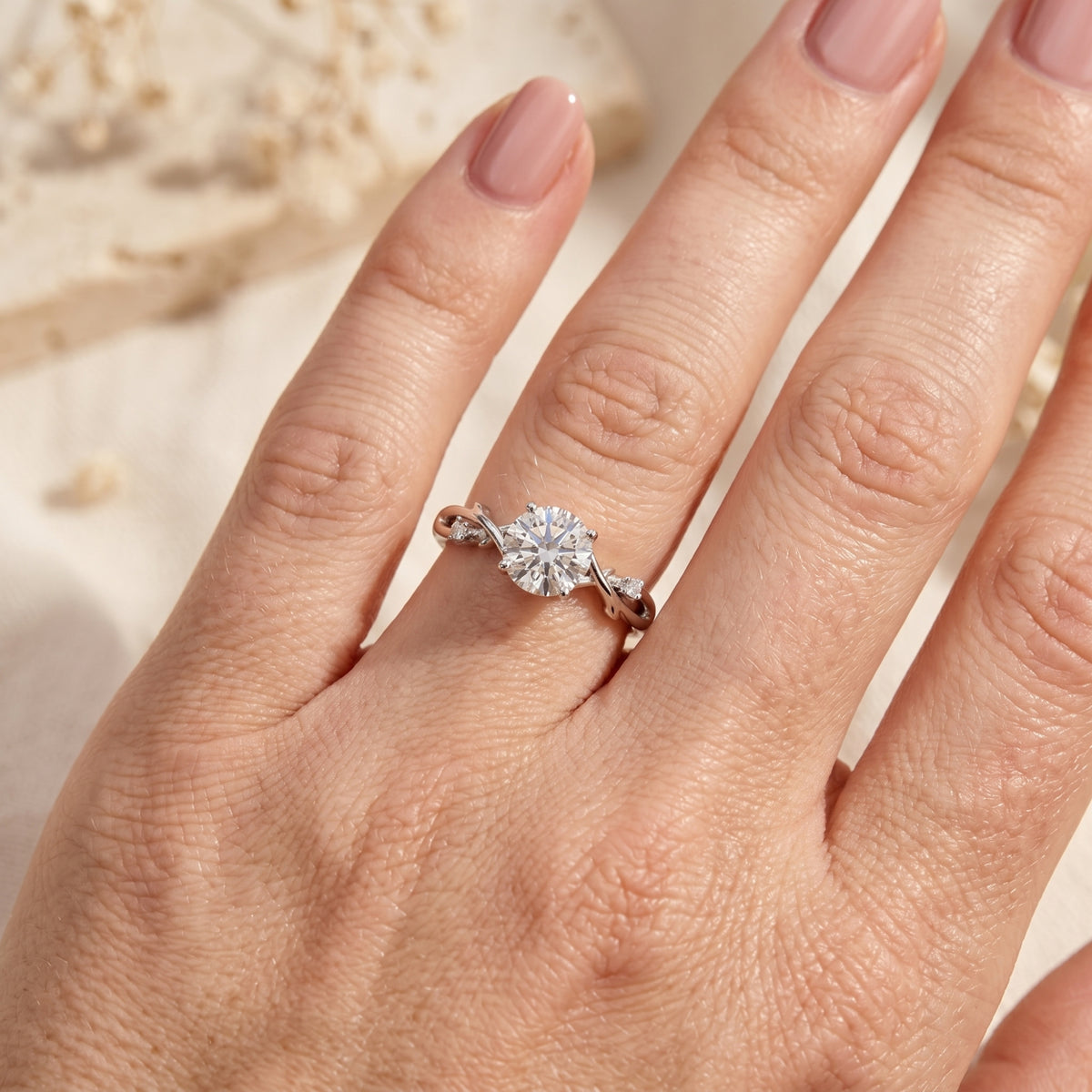 Sterling silver Sylvella ring with a 2ct round moissanite center stone worn on a woman's hand.