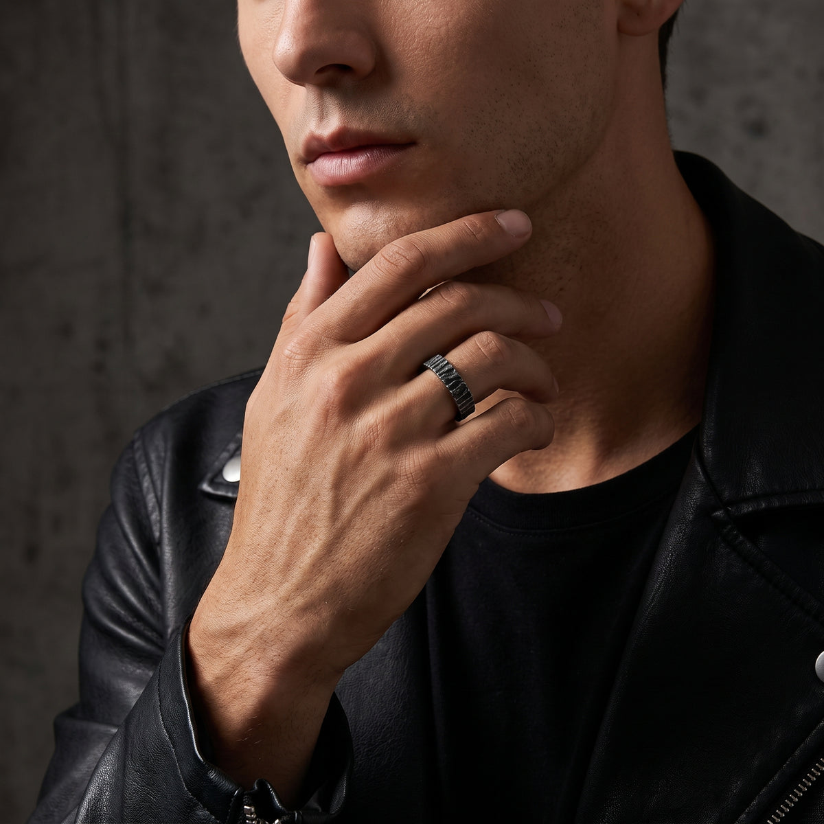 Man in a black leather jacket wearing the silver bark textured open band ring.